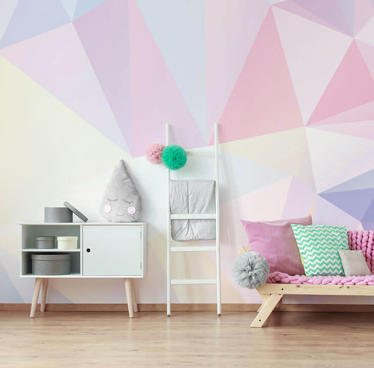 pastel shaded geometric wallpaper in girls bedroom with pink couch and white cabinet