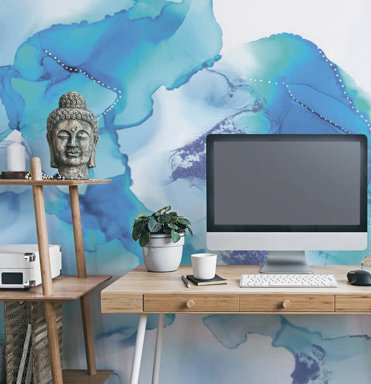 blue and purple tie dye effect wallpaper in office with wooden desk, white desk lamp and buddha head