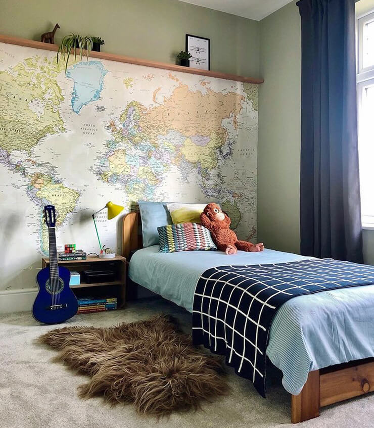 pastel toned world map wallpaper in kids bedroom with monkey teddy and guitar