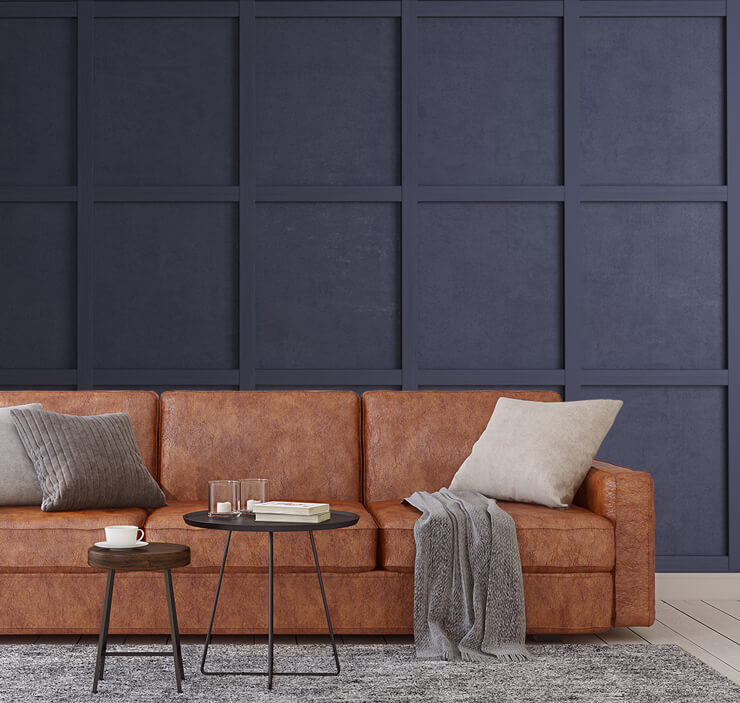 dark navy panel effect wallpaper with brown leather sofa