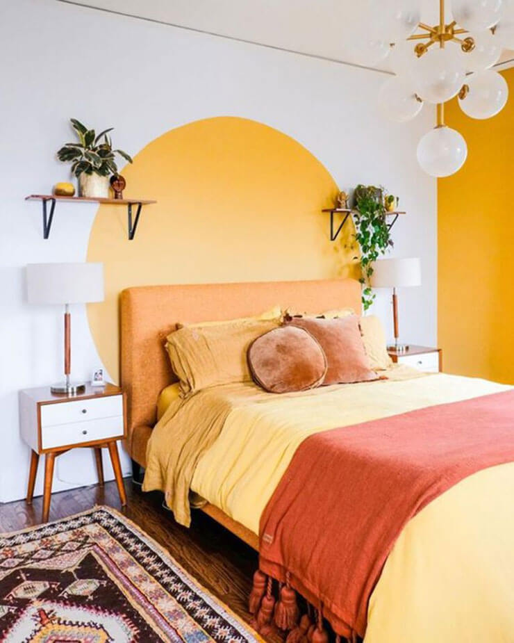 Warm, orange room with a painted circular headboard