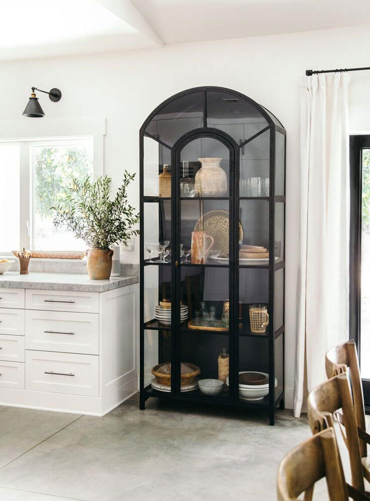Black curved display cabinet in a white kitchen