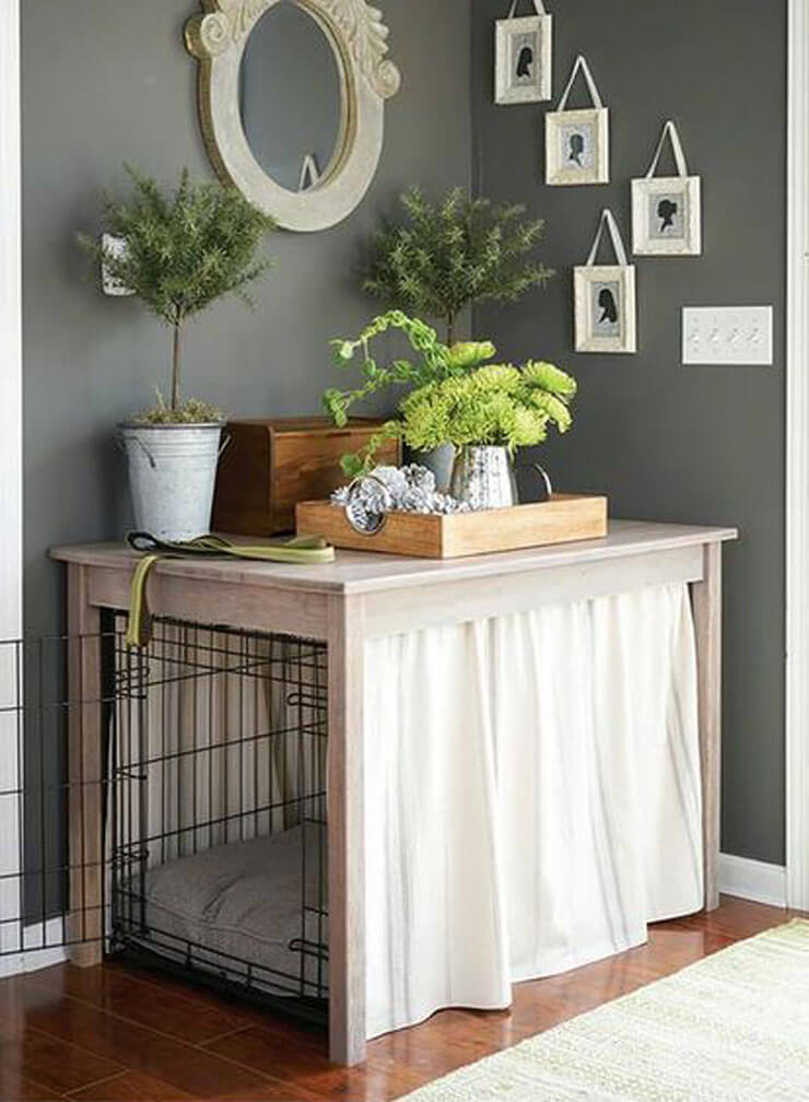 Dog crate under a table with a white curtain