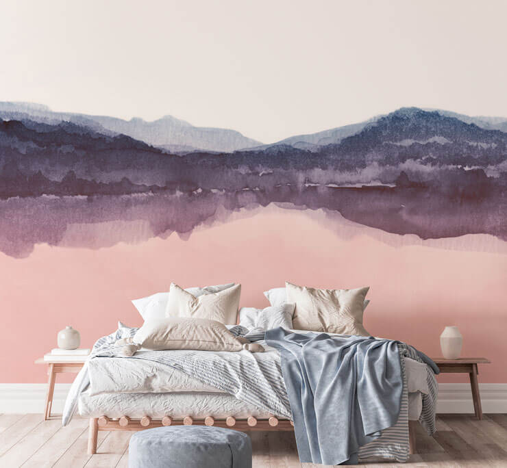Pink watercolour wallpaper in a bedroom with cream and pale blue sheets