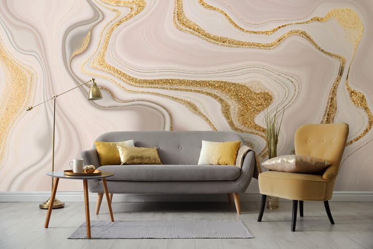 Grey and gold furniture in a living room with a pink and gold wall mural