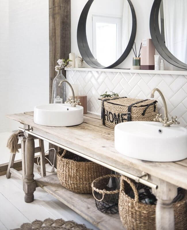 Reclaimed wood vanity with white sinks in a bathroom with wicker storage baskets