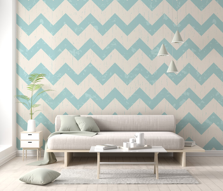 Living room with a light grey couch with a light blue chevron wallpaper