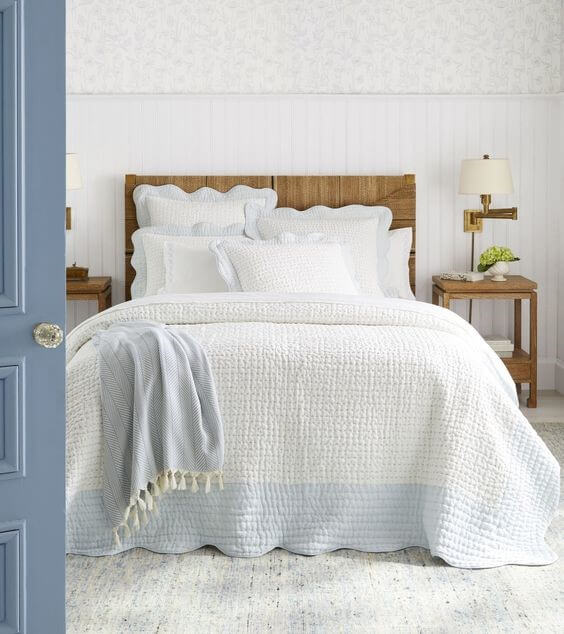 White and light blue bedroom with white bed sheets and light blue walls