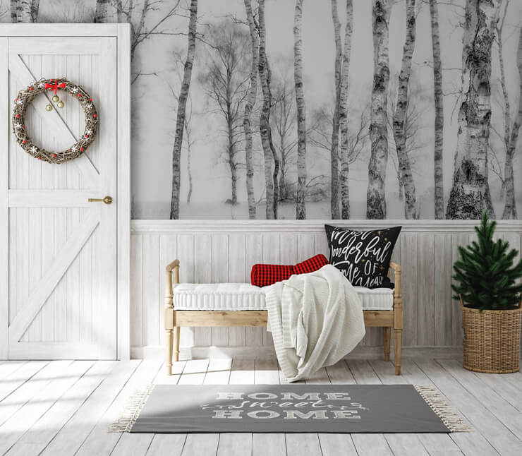 Scandinavian Christmas Decorations in a hallway with a black and white tree mural and a green Christmas wreath