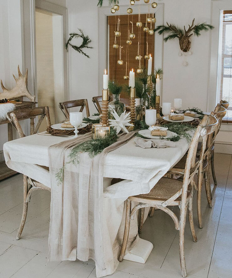 Scandinavian inspired Christmas table decor in a neutral dining room with wooden chairs