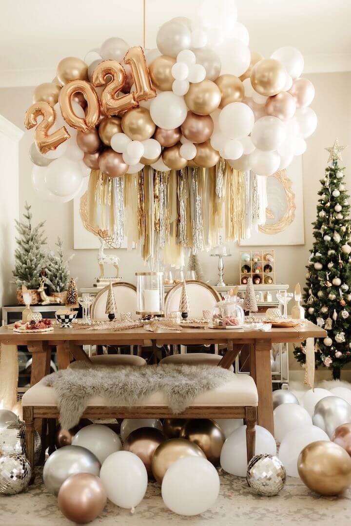 Neutral dining room with wooden furniture decorated with gold and pink balloons