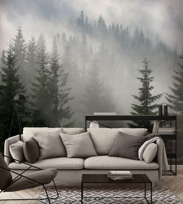Dark living room with a grey sofa and misty forest wallpaper