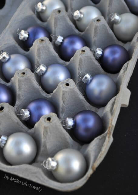 Christmas storage hacks of a grey egg box holding blue and silver baubles
