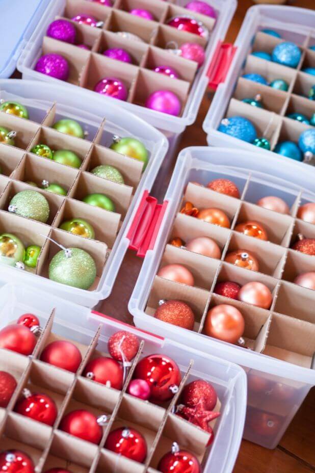 Plastic tubs holding colour co-ordinated Christmas baubles with cardboard dividers