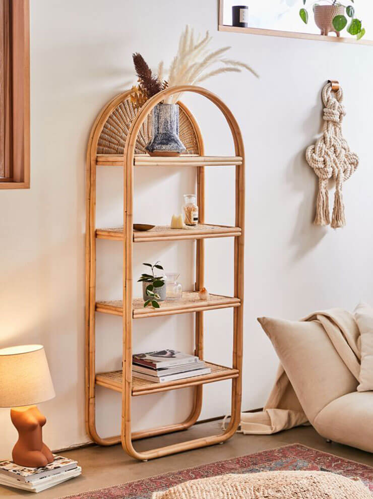 White walls with a tall, curved rattan unit with a wooden floor and rattan rug