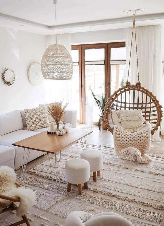 Neutral living room with a white sofa and beige rug with a rattan chair