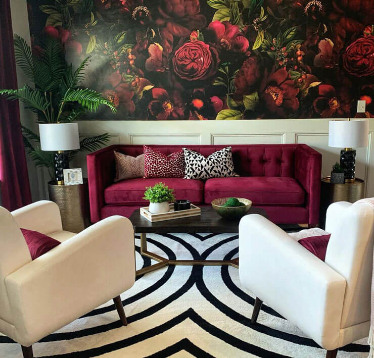 Deep red and white living room with a red sofa and white chairs with a dark maroon floral wallpaper