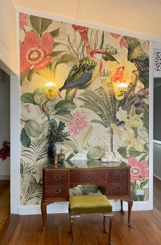 Muted yellow and beige tropical bird jungle print wallpaper with dark wooden furniture