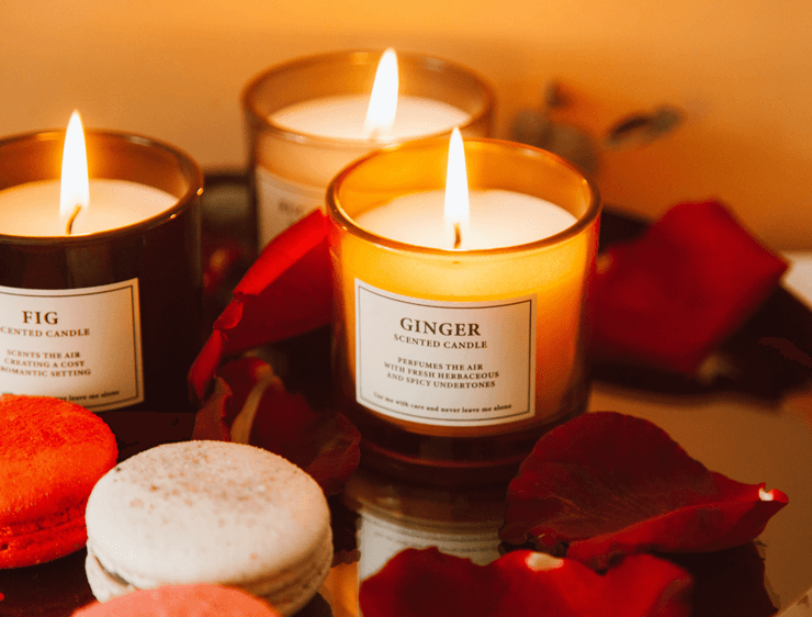 Ginger scented candle on a gold tray with red rose petals