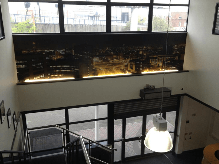 strip of wallpaper showing a city at night on staircase in office