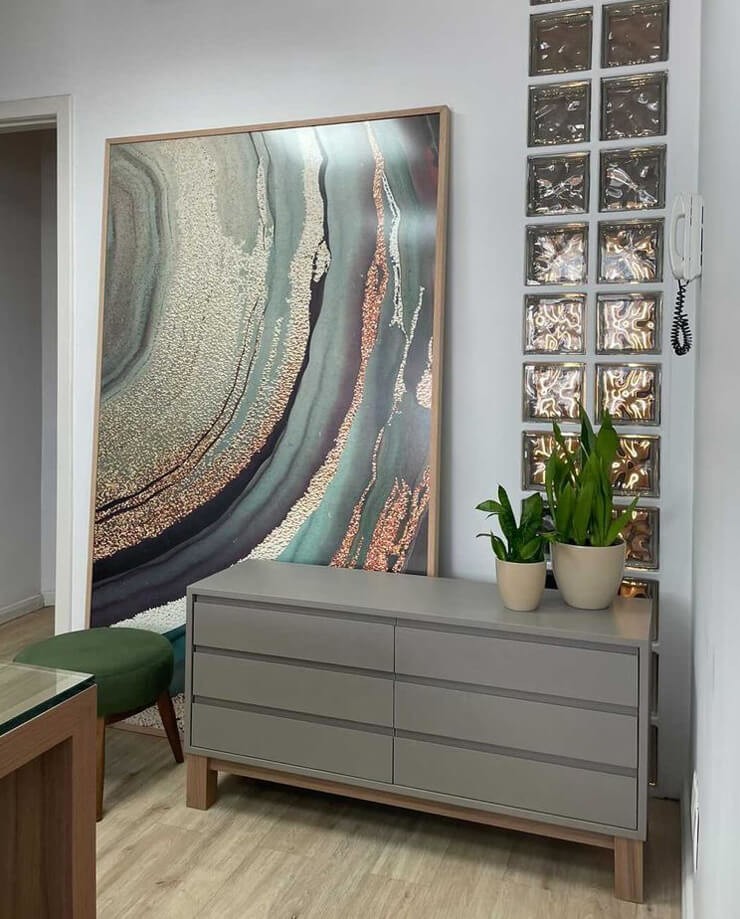 circular geode wallpaper in a frame beside grey drawers