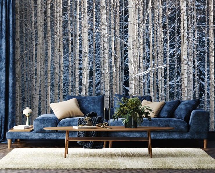 Blue living room with a snowy forest wall mural and a blue sofa at Christmas