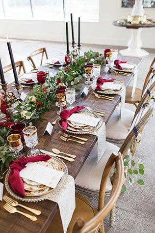 Dark wooden table with gold and white accessories with a green and red garland