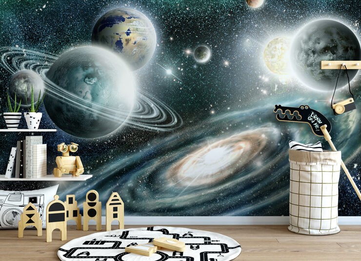 Large planets with turquoise and light blue stars in a children's bedroom with wooden space toys, white shelves and a wooden floor