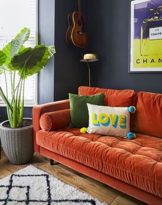 bright orange sofa in navy living room