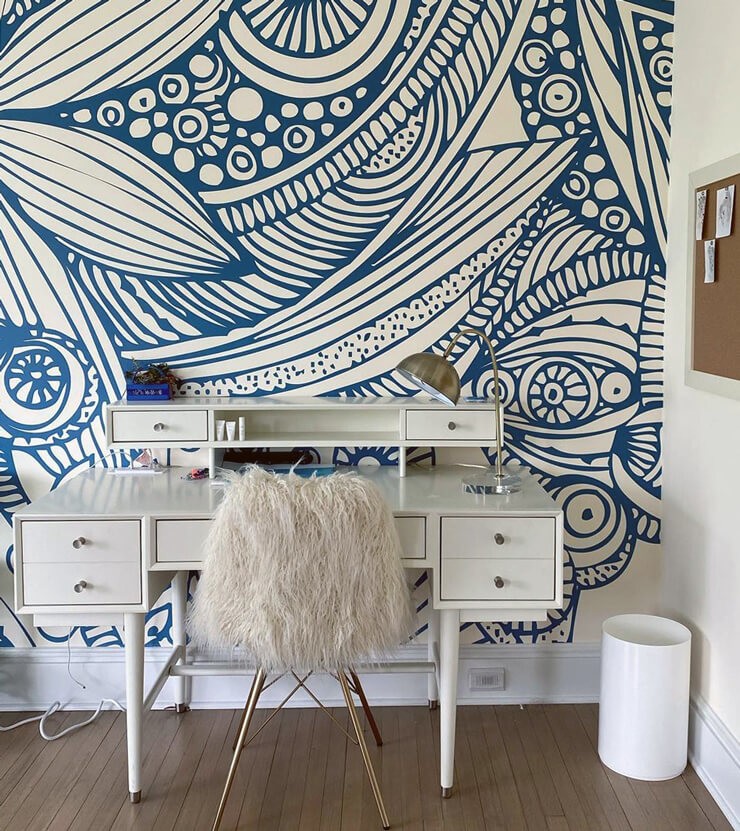 off white and blue doodle 70s wallpaper with white desk and sheep rug chair