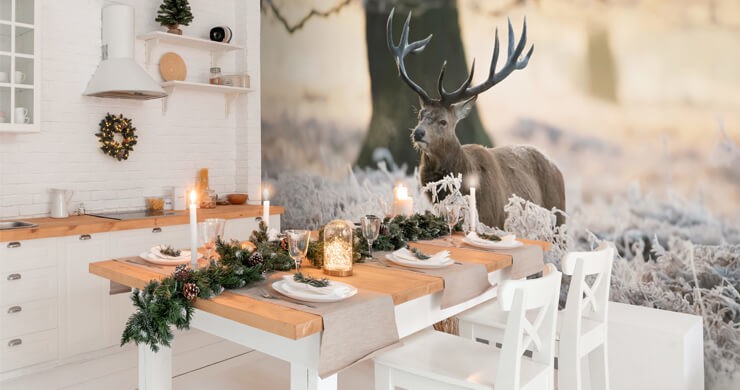 Christmas table decor in a white kitchen with pine furniture and a realistic stag wall mural
