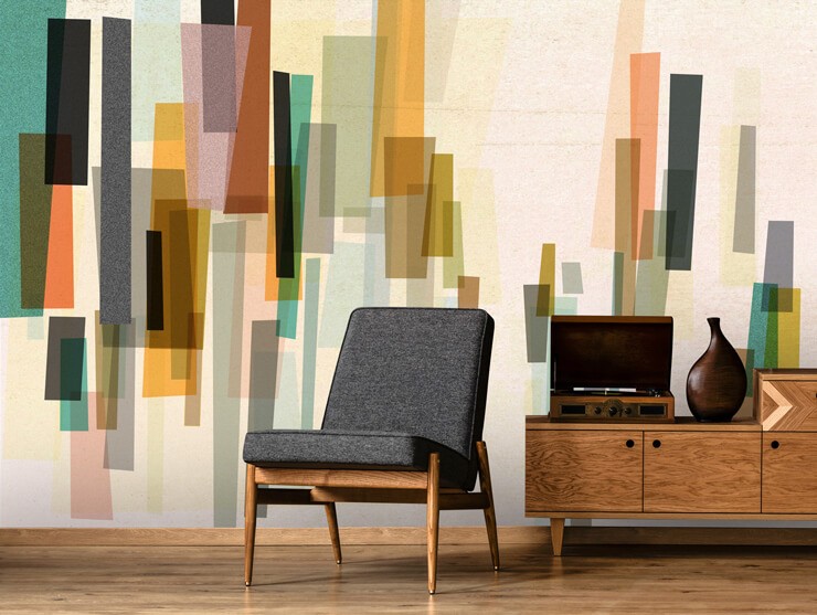 retro abstract art of rectangles in terracotta, black and teal shades wallpaper in room with mid century wooden and grey fabric chair