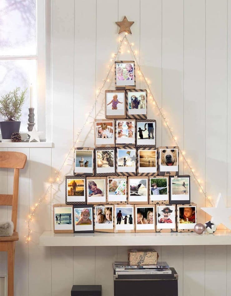 Christmas tree made from stacked photographs on a cream wall
