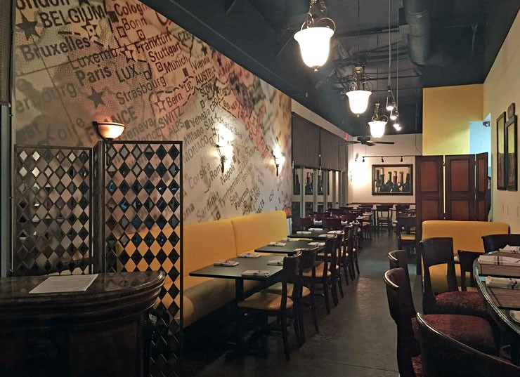 Vintage map wall mural in a bar interior with dark wooden furniture