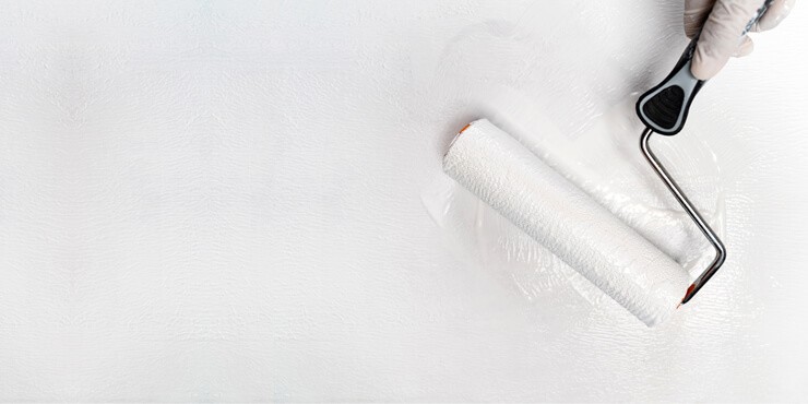 paint roller painting white on wall