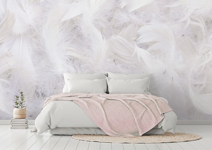 White realistic feather wall mural in a bedroom with white and pink bedsheets