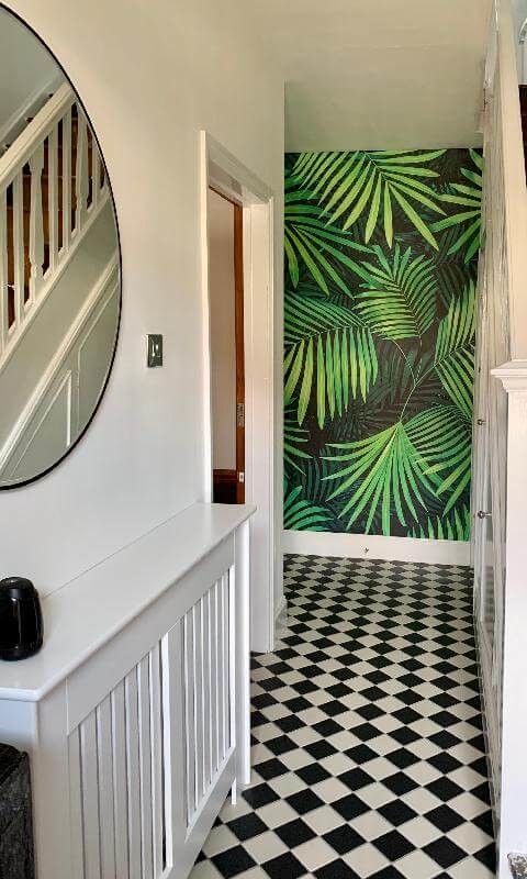 green palm tree wallpaper in black and white entryway