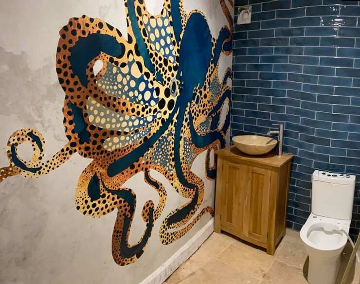 navy and gold wallpaper with octopus in downstairs bathroom