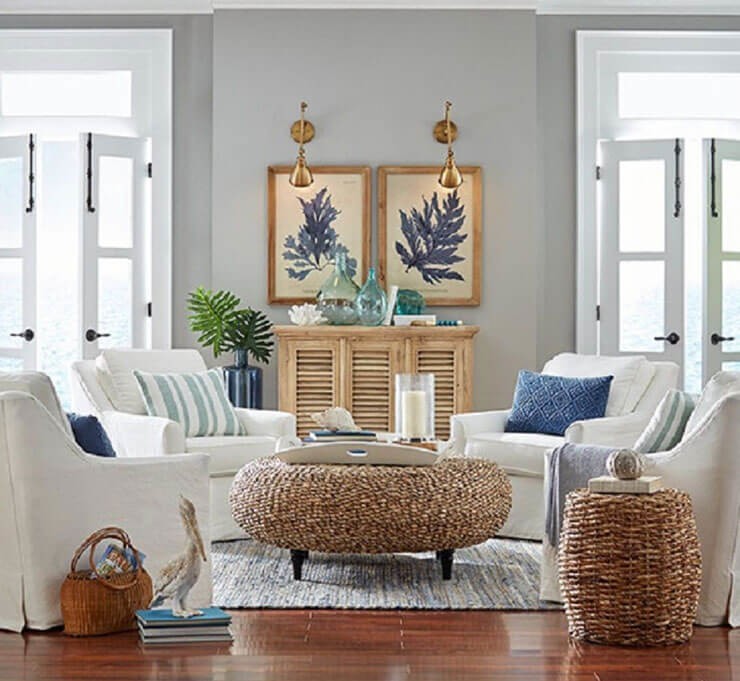 Coastal living room with white chairs and blue cushions with a rattan coffee table