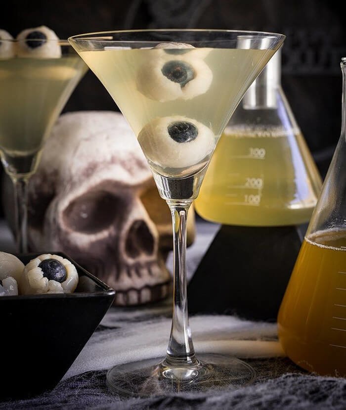 Green halloween martini with edible floating eyeballs