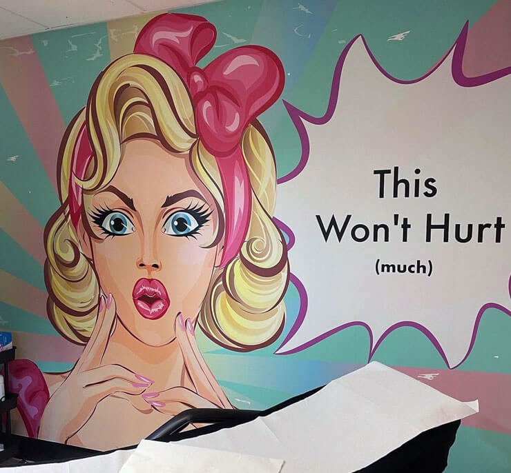 Colourful pop art mural with a speech bubble in a salon with a black chair