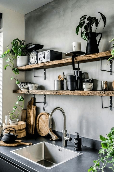 Grey kitchen wall with wooden shelves and black accessories