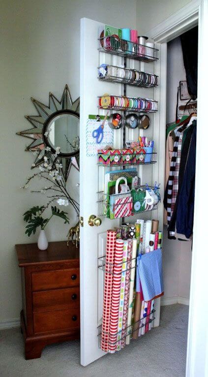 White wooden door with metal over door baskets holding wrapping paper and ribbons
