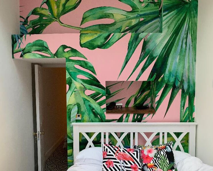 pink and green leaf wallpaper on unusual wall