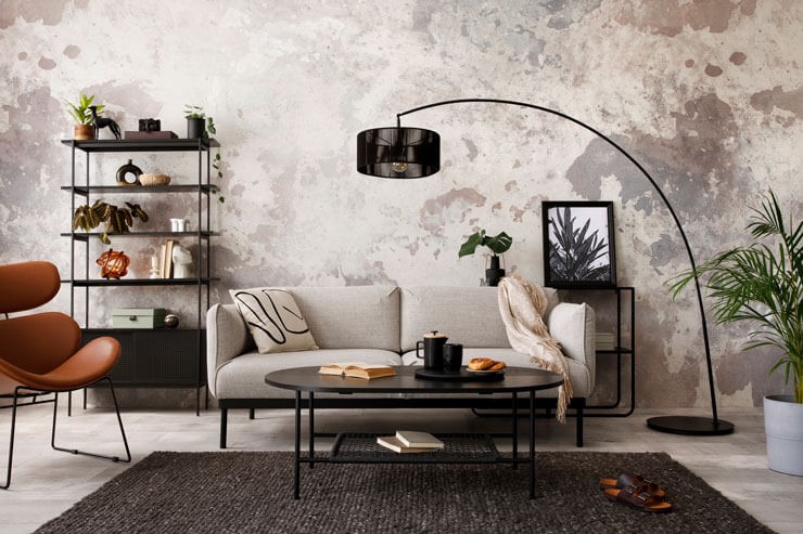 Industrial style living room with a grey sofa, a black rug and black accessories