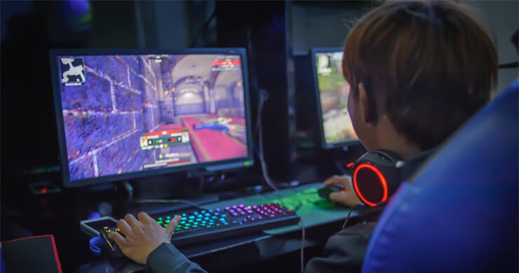 boy with headset and RBG tech in gamer room