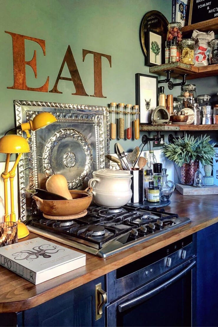 Kitchen interior with a green wall, brass wall art, and excessive ornaments