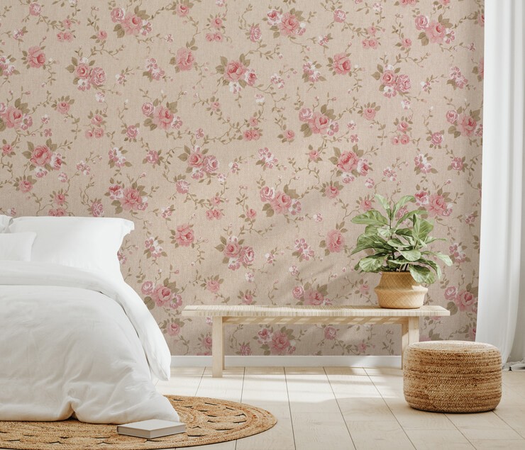 Bedroom with white bedsheets and a wicker rug with a pink floral wallpaper