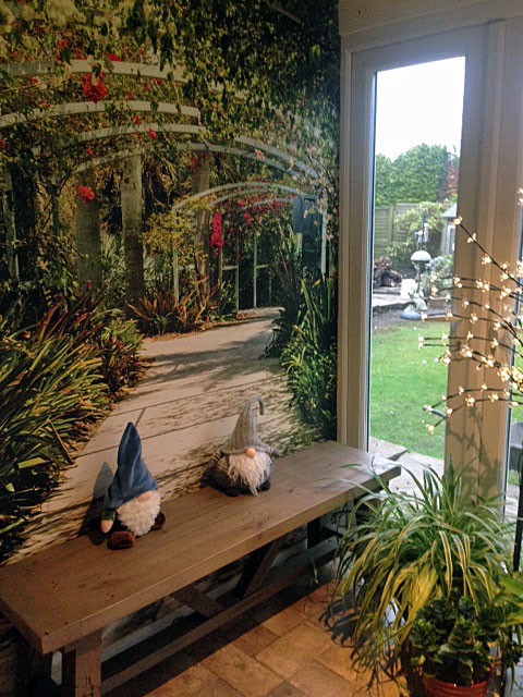 arched garden path wall mural in garden themed conservatory with gnome ornaments