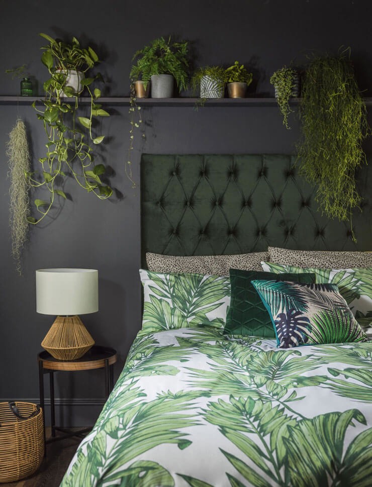 Dark bedroom with floral bedsheets and trailing plants